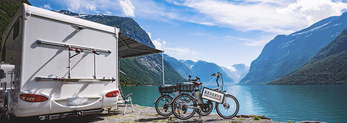 Reserve Your Retirement sign hangs off the handlebars of a bicycle next to an RV camper.