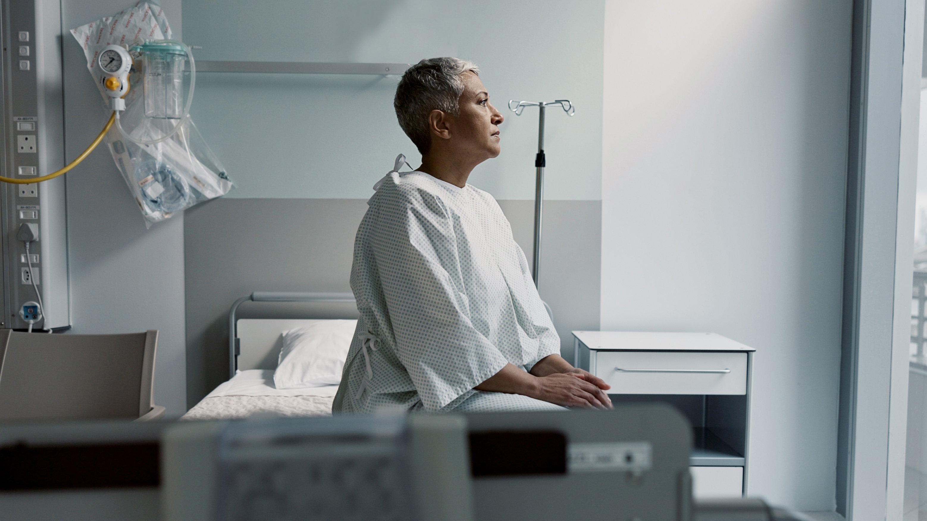 Patient sitting in a gown on examination table