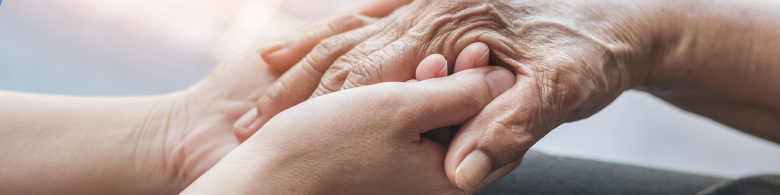 a set of hands holding an elderly person's hand